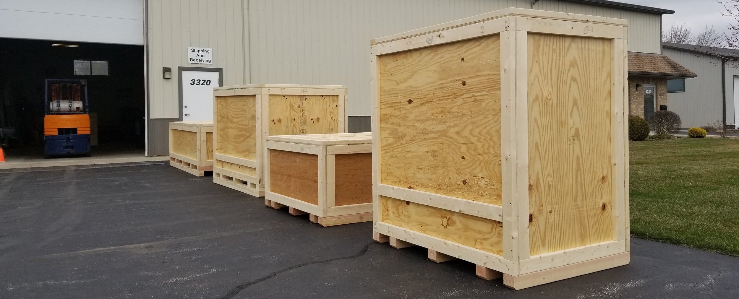 four large crates sitting outside on a businesses driveway