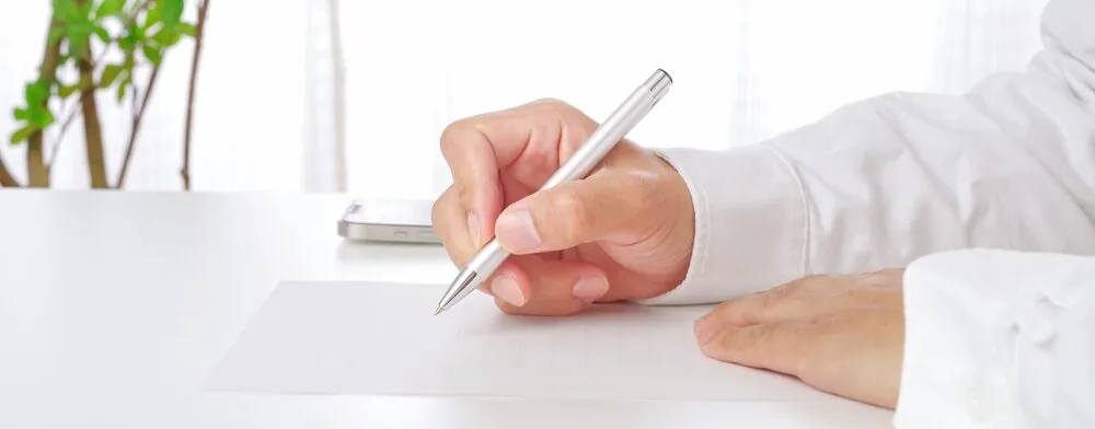 hand holding silver pen representing a consignor and consignee signing a BOL or POD
