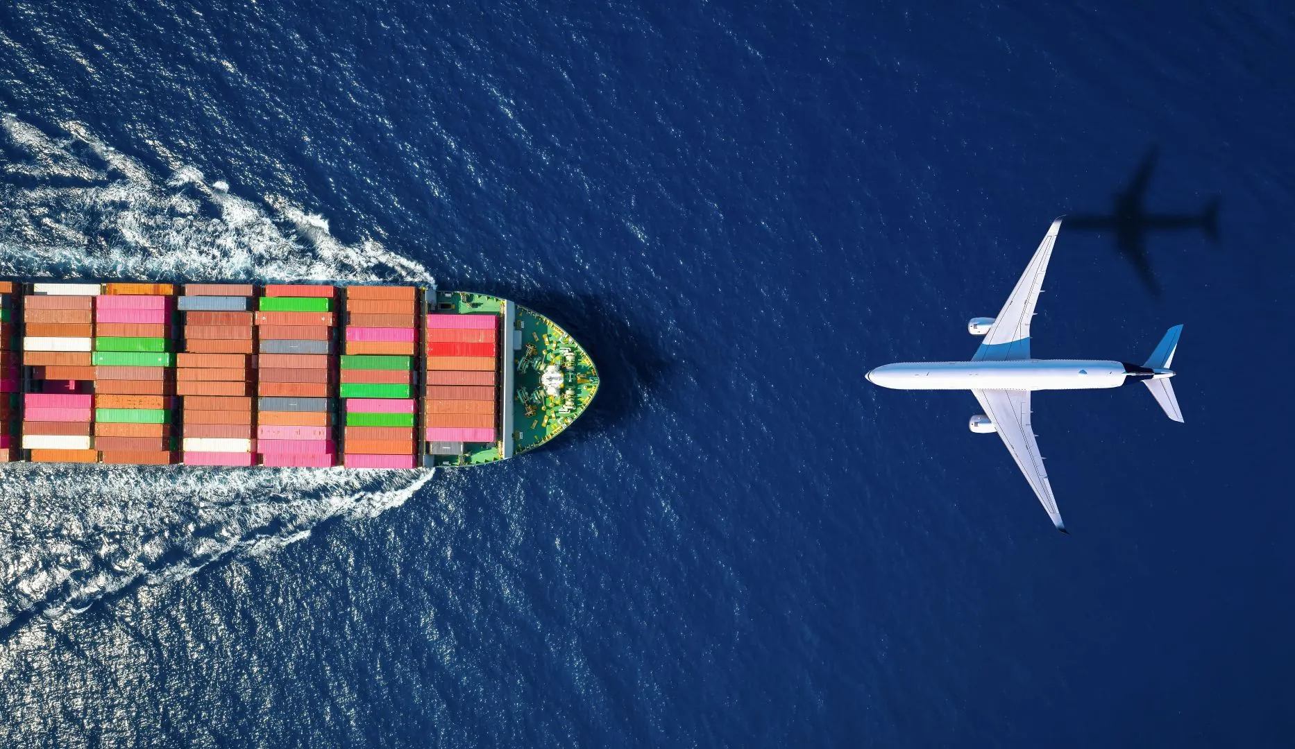 aerial view of container ship sailing and airplane flying