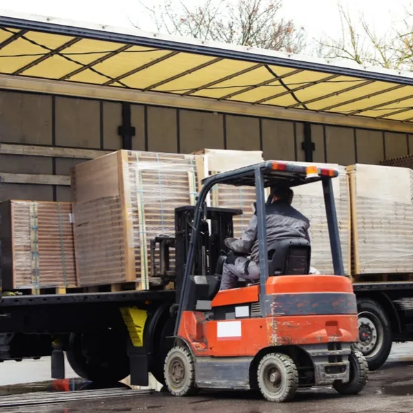 Forklift loading freight onto a flatbed trailer