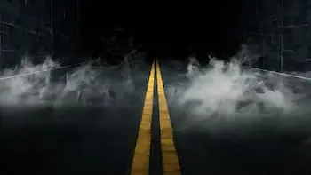 America's Haunted Highways a dark road leading into a brick tunnel with fog rising from the concrete