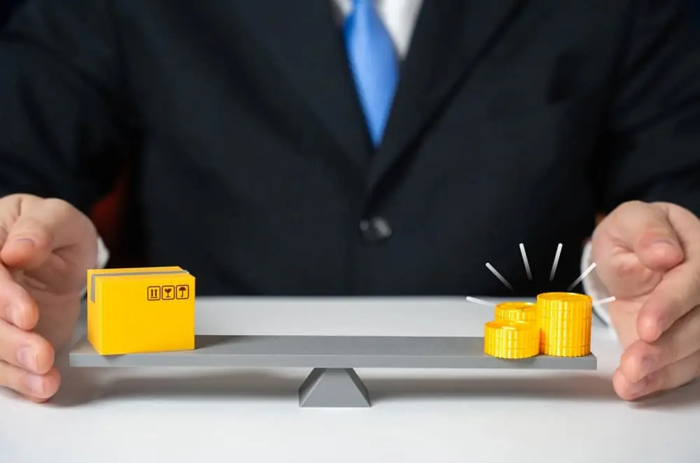 Dynamic Pricing businessman balancing small cardboard box toy and small pile of coins on scale