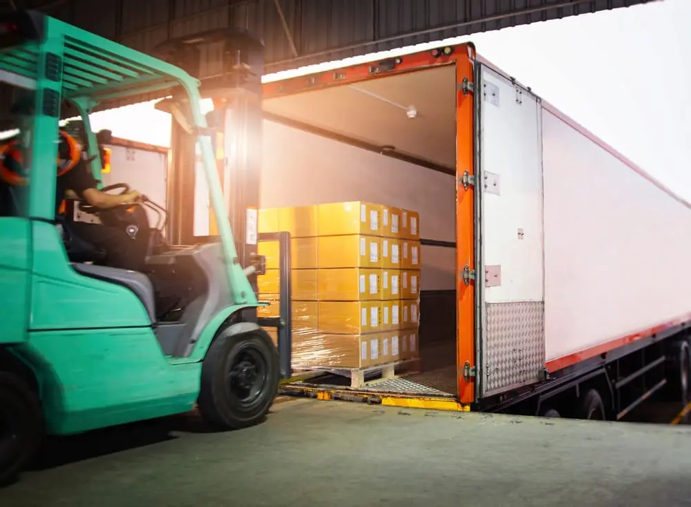 Dynamic Pricing green forklift driving a pallet into a trailer