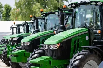 green tractors parked in a line preview