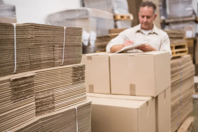 warehouse worker taking inventory of freight packaging materials