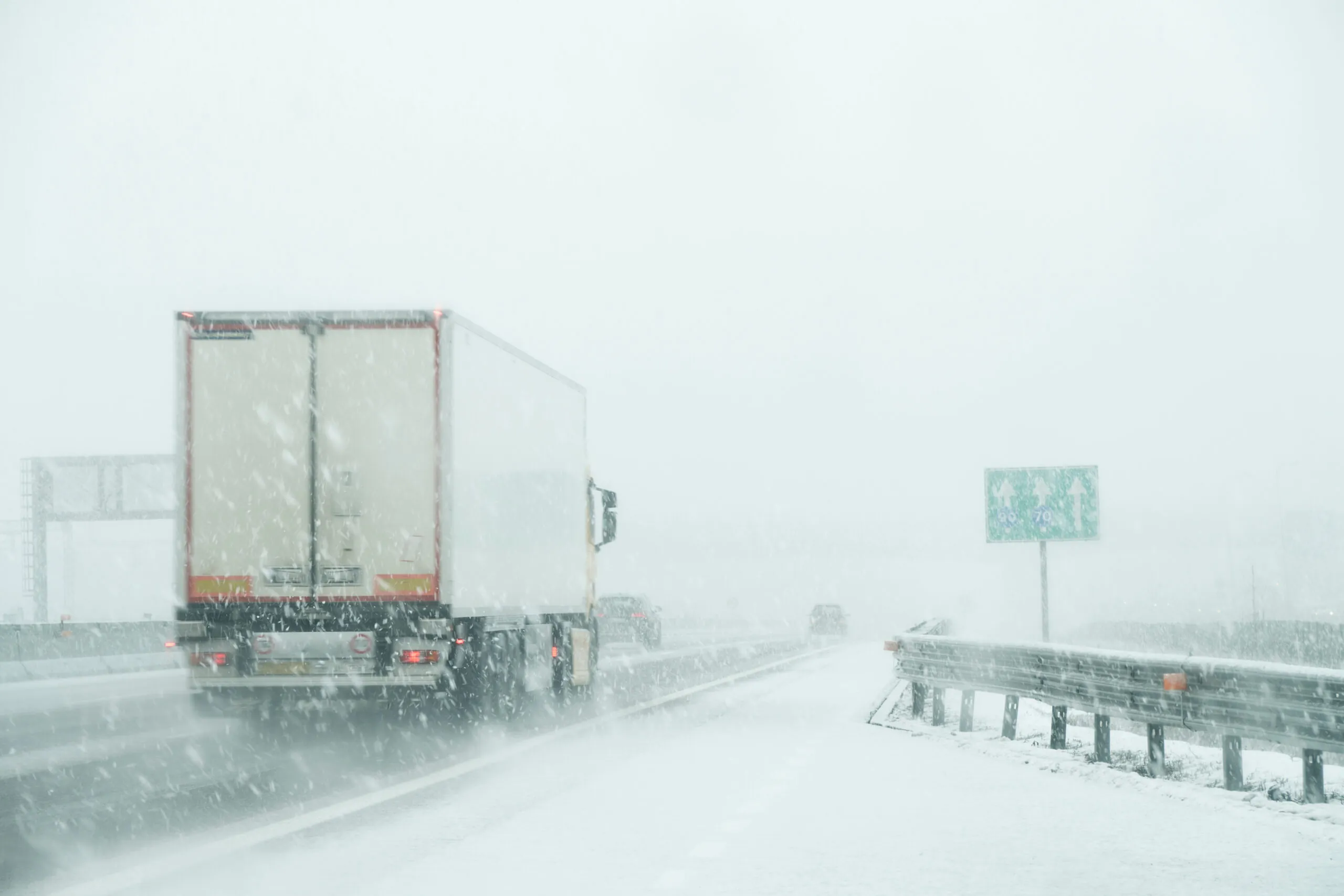 semi truck driving highway in snow