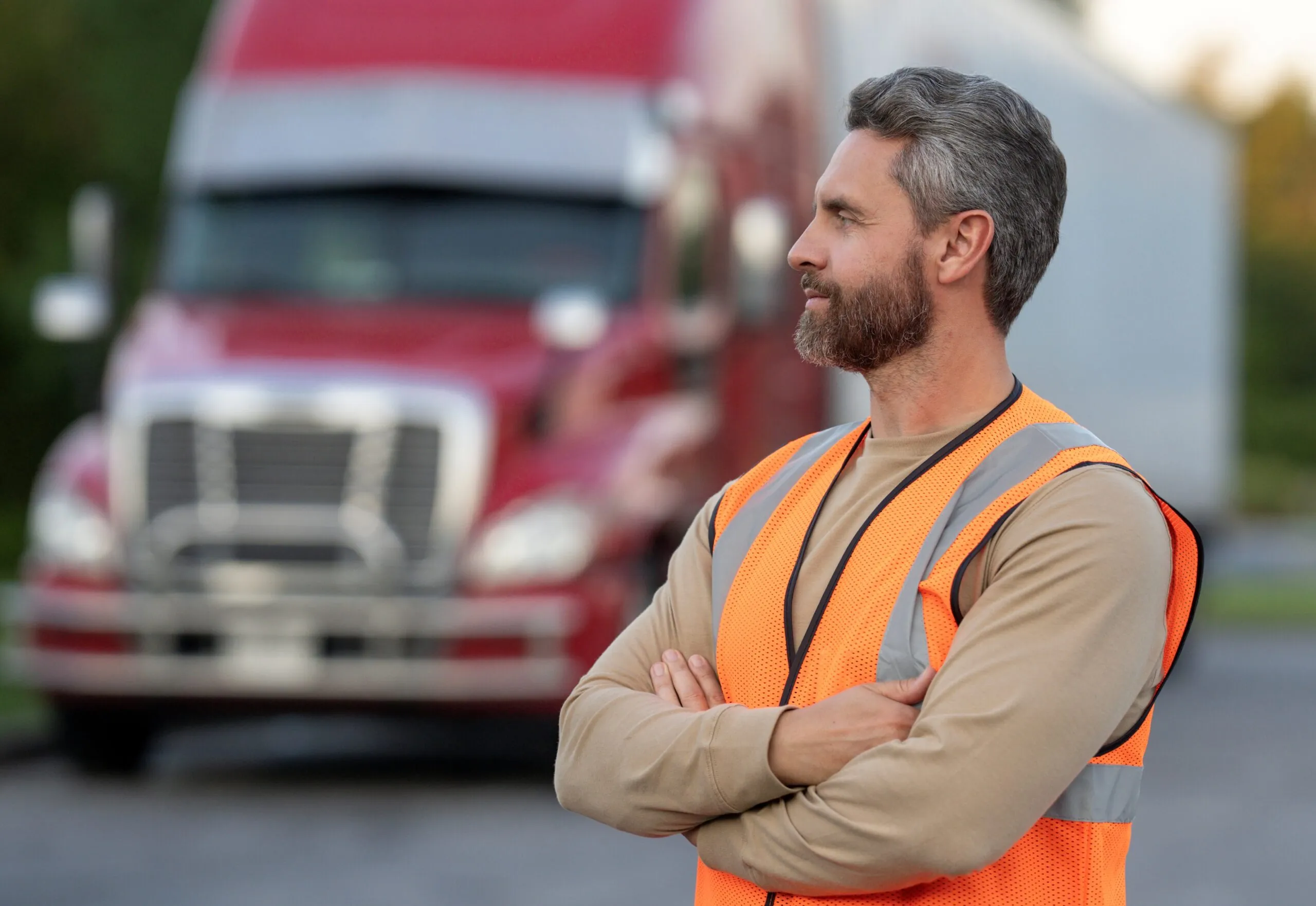 truck driver looking left and standing in front of semi truck