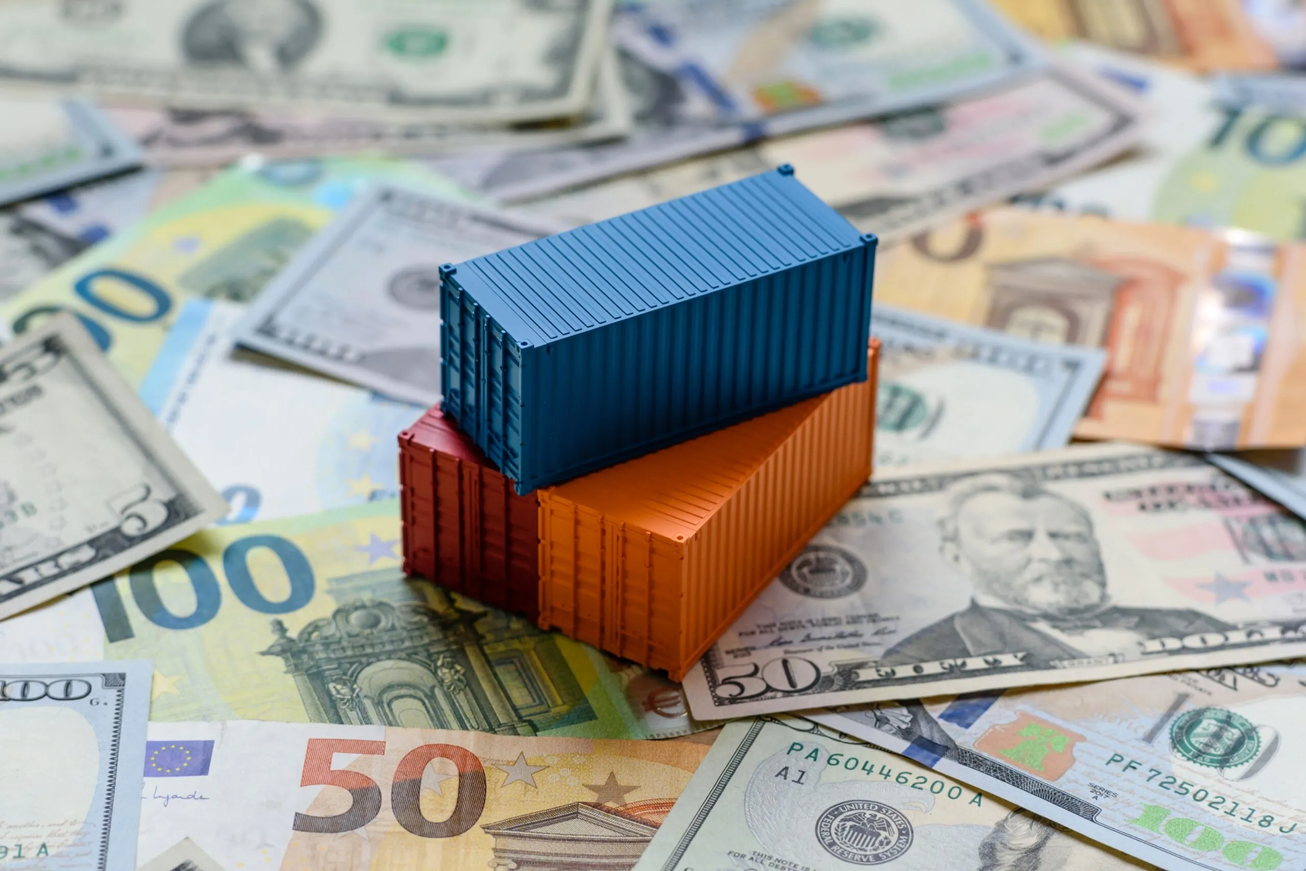cargo containers stacked on top of euro and dollar bills, trade wars