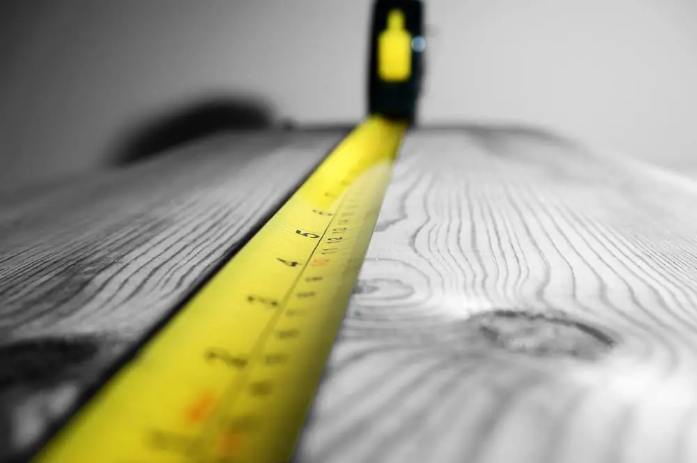 dimensional weight tape measure measuring a piece of wood