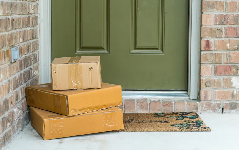 packages delivered to a porch with a green door