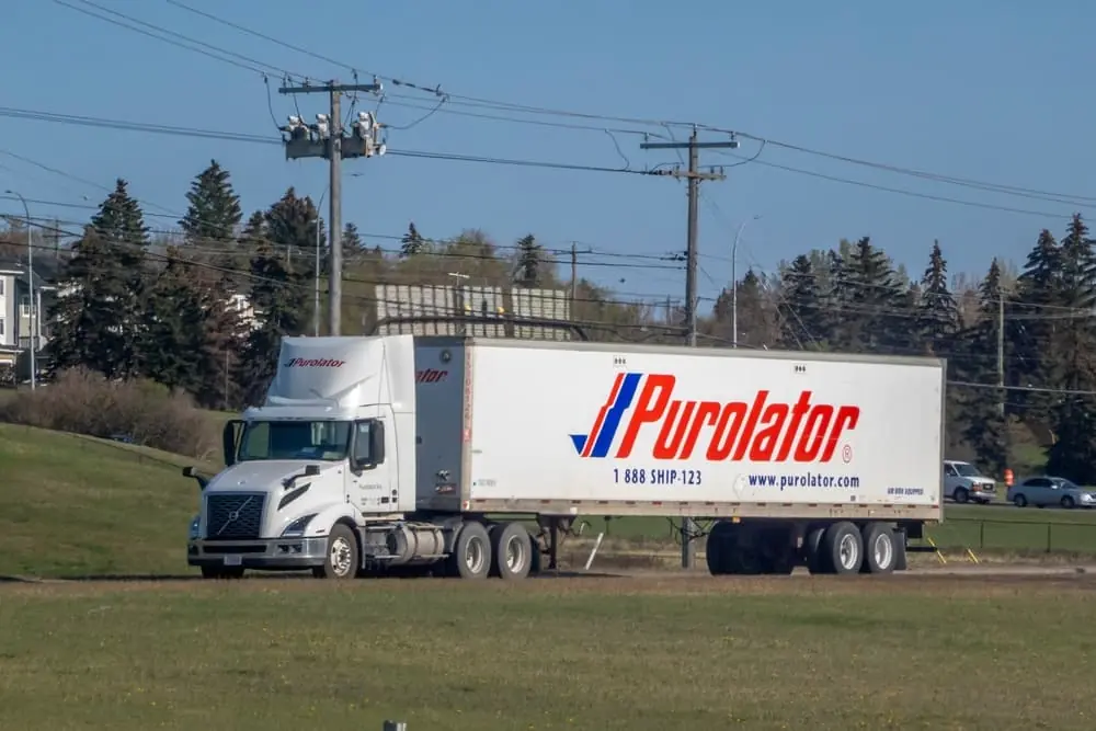 A Purolator trailer truck on a highway