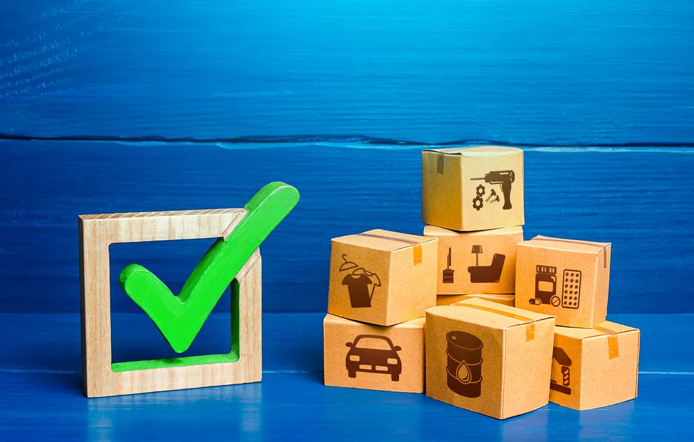 stack of boxes next to a green wooden check mark