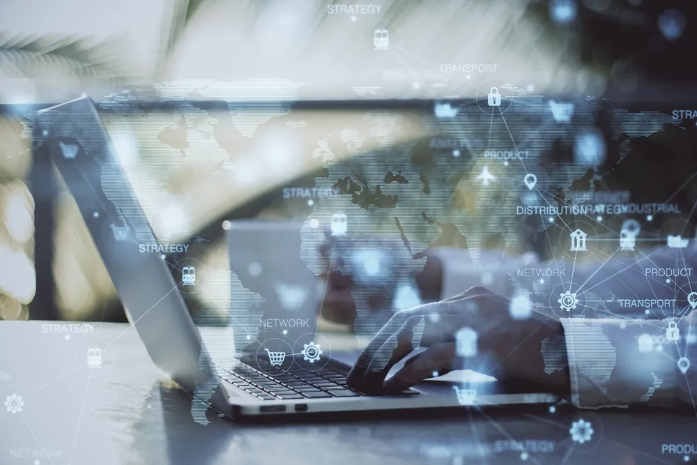 Summer Shipping Tips man using laptop to book freight while thinking about supply chain visualized on top of image