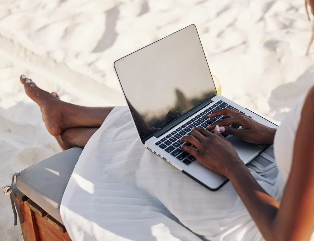 hands on laptop on sand