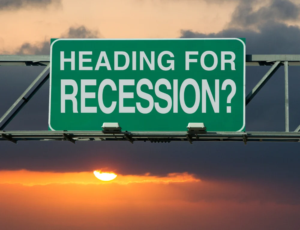 highway road sign saying "heading for recession"