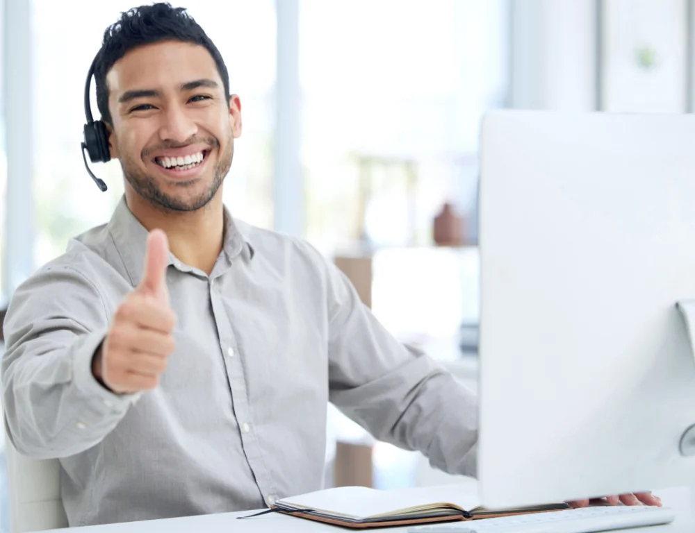 young man using a headset and showing a thumbs up