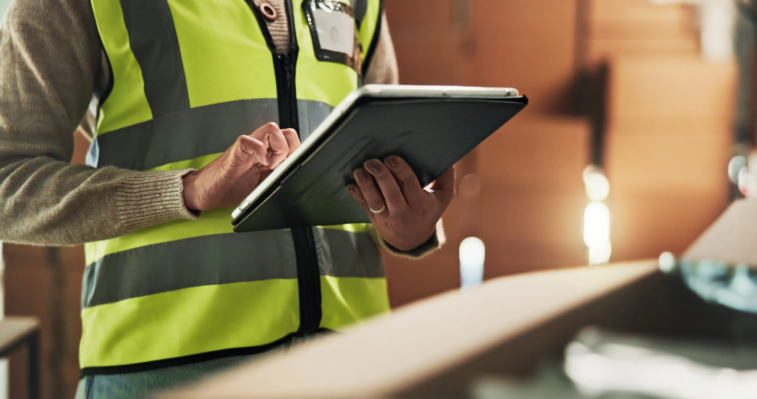 warehouse worker checking tablet by boxes