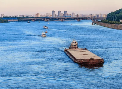 Barge Shipping empty barge being pulled by a tugboat down stream towards city bridge