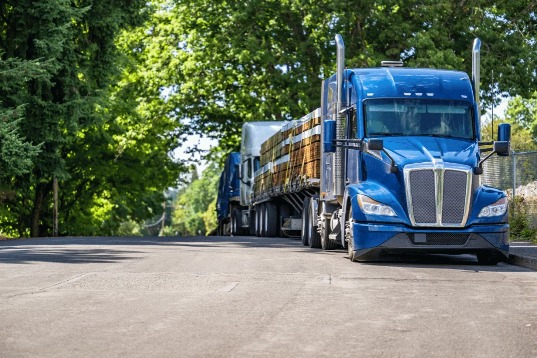 Special Requirements When Shipping Freight blue semi trailer truck with lumber strapped on parked on the street