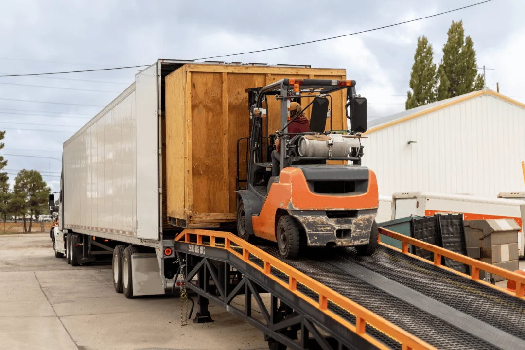 Special Requirements When Shipping Freight forklift driver moving large crate into semi trailer