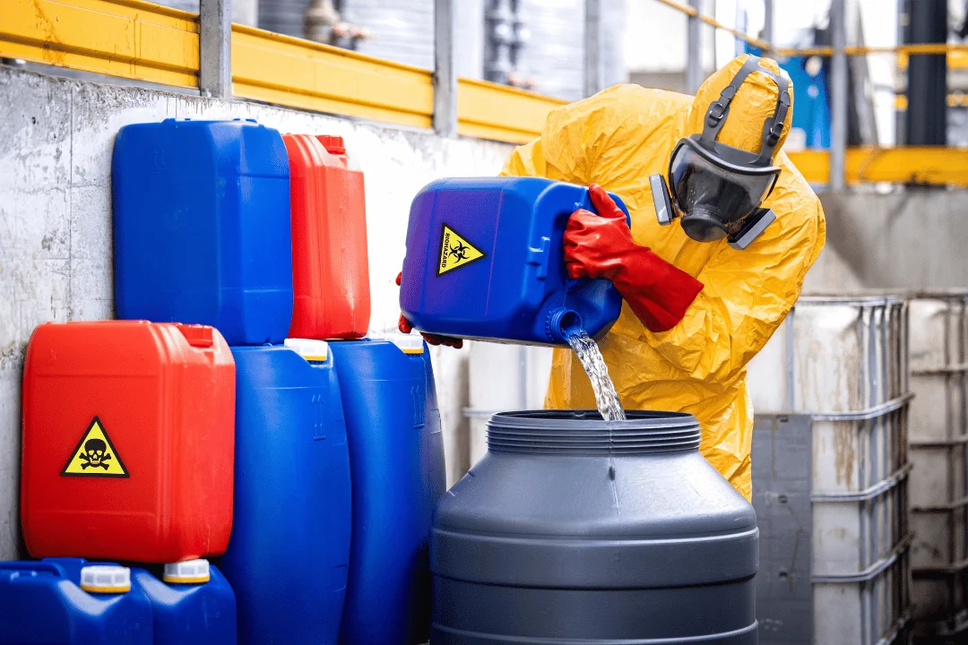Special Requirements When Shipping Freight hazmat worker in PPE pouring chemical into plastic barrel