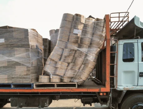 pallet of logs falling over on flatbed truck