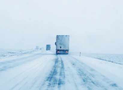 semi trailers driving down highways in heavy snowfall