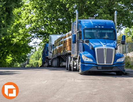 blue flatbed trailer parked on side of the road