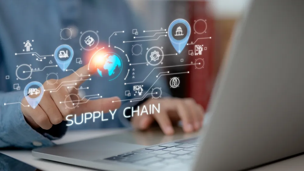 man at a laptop computer with a visual representation of Supply Chain