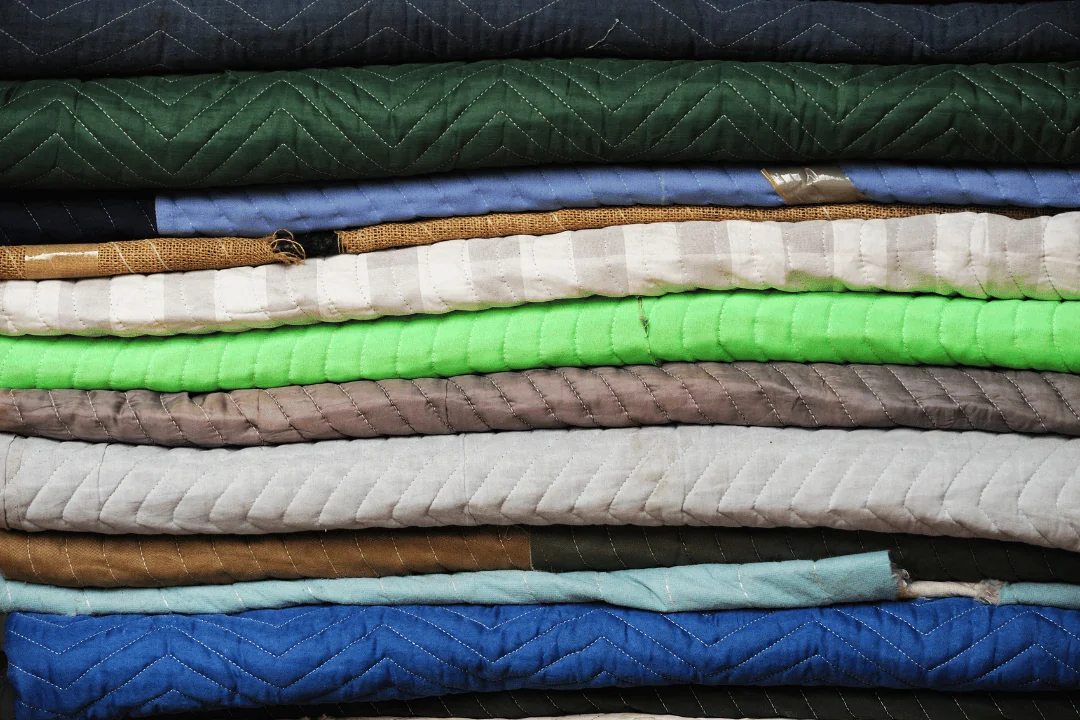close up of a stack of moving blankets in different colors