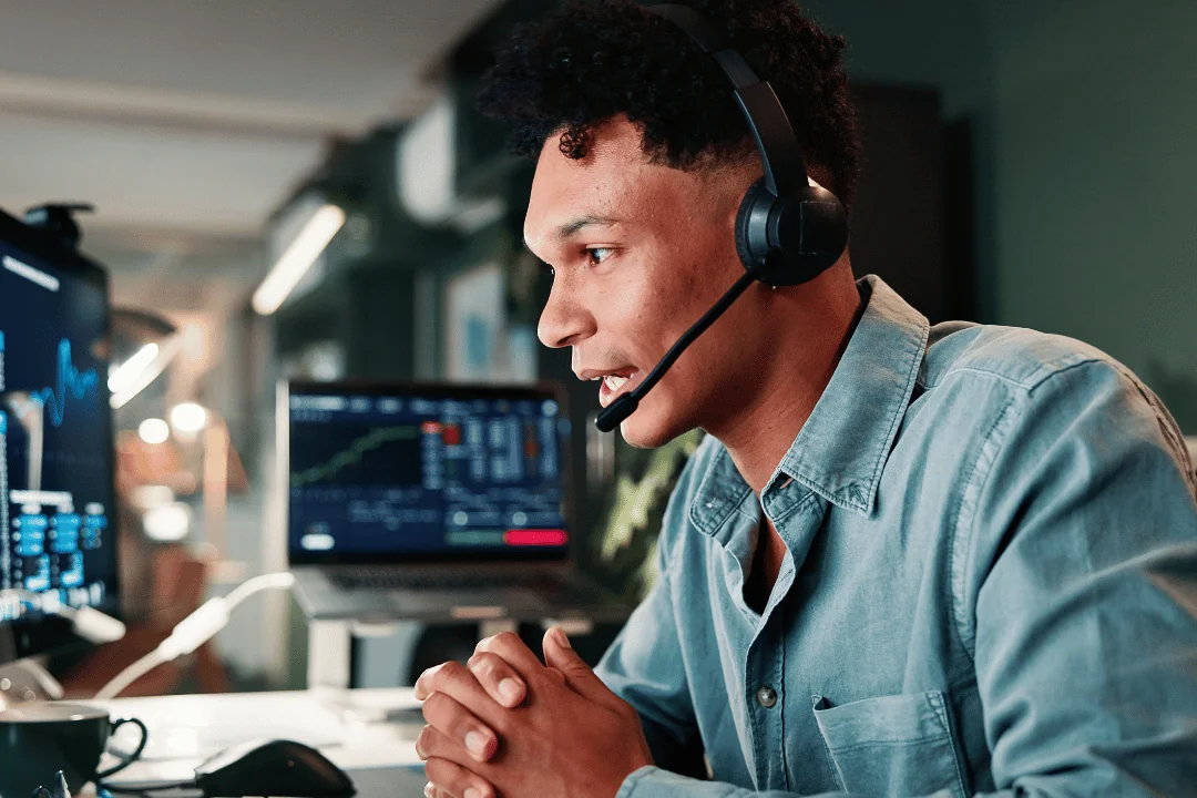 Customs Brokerage and Freight Clearance call center agent on the phone surrounded by laptop and monitors