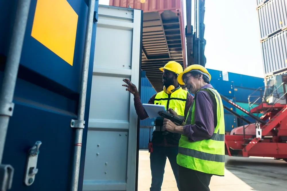 Why Bigger Ships Aren't Always Better for Global Transportation port workers in front of open container