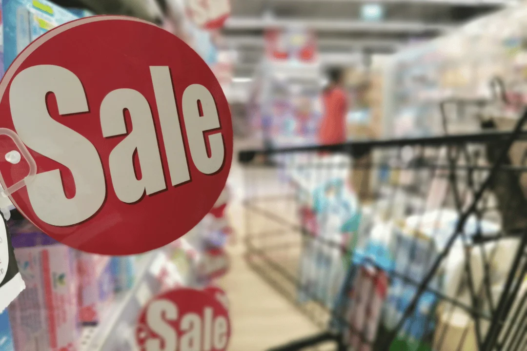 What Trends Will Shape Holiday Shipping a round red Sale sign in a store with a shopping cart in the aisle