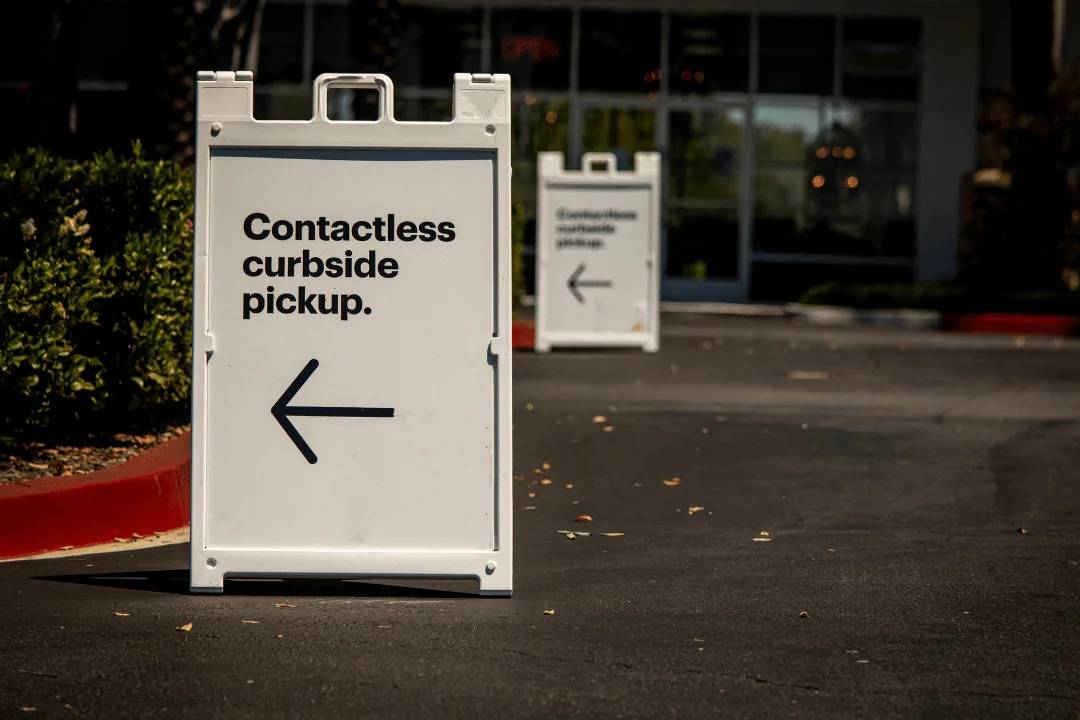 What Trends Will Shape Holiday Shipping a white folding sign in front of a store that says Contactless curbside pickup with an arrow pointing left