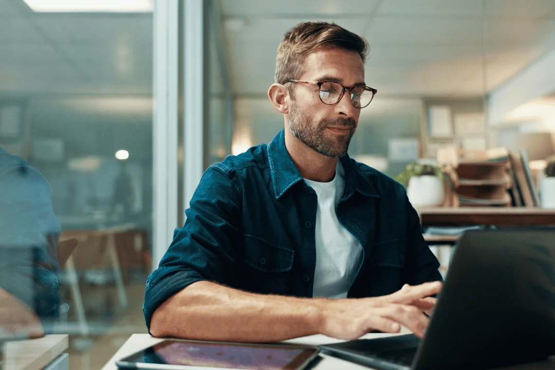 What Trends Will Shape Holiday Shipping businessman in casual clothing reading over the news and typing on his laptop