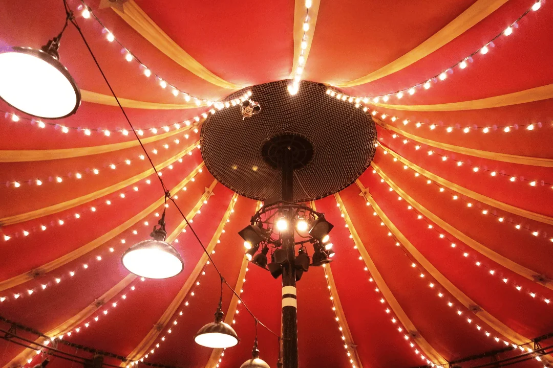 Freight Shipping Circuses top of a red circus tent interior with hanging string and spot lights