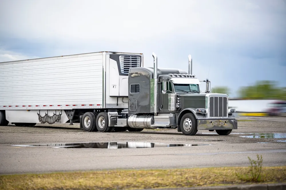 The History and Impact of Cold Chain Logistics gray semi truck pulling a reefer trailer in a parking lot