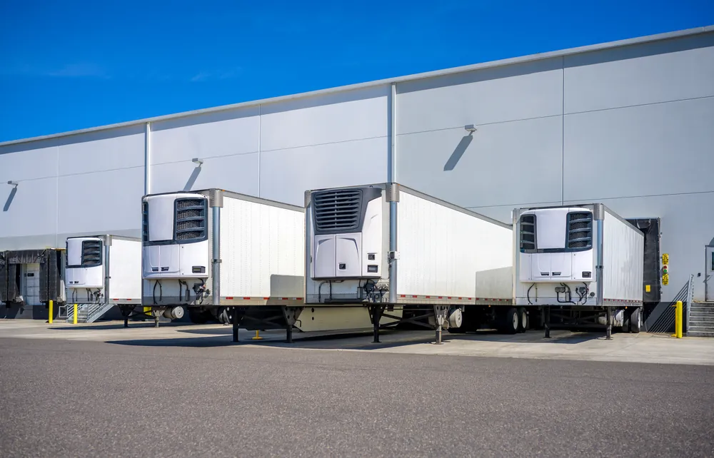 The History and Impact of Cold Chain Logistics reefer trailers at a warehouse loading dock
