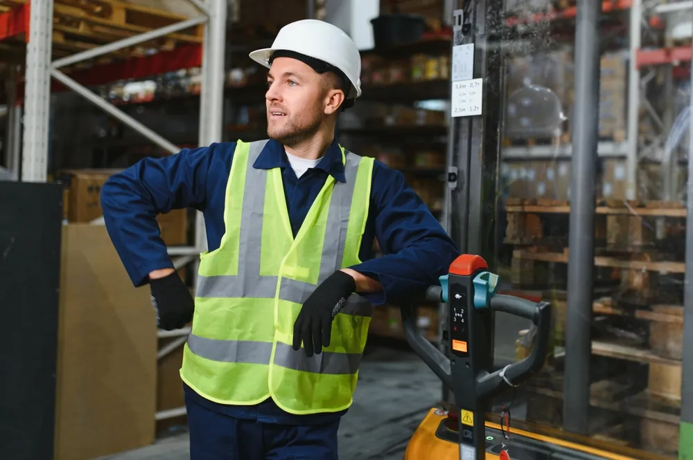 warehouse worker leaning on dolly