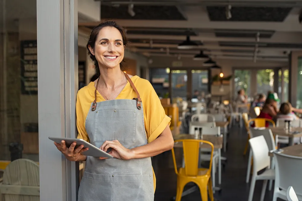 The Quiet Season lady with tablet outside business smiling