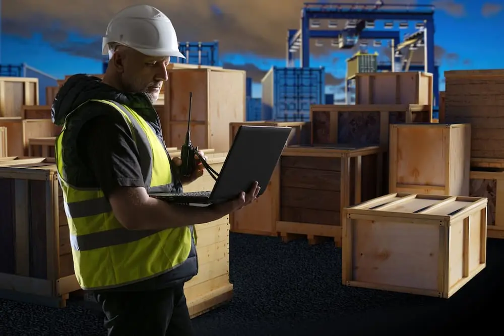 Are Your Shipments Ready for Peak Season port worker looking at laptop