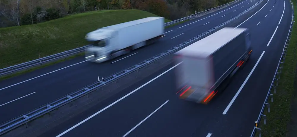 Construction Deadlines semi trucks speeding down opposite sides of the highway