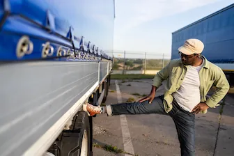 Easy Exercise Activities For Any Trucker COMP SM trucker stretching on truck wheel