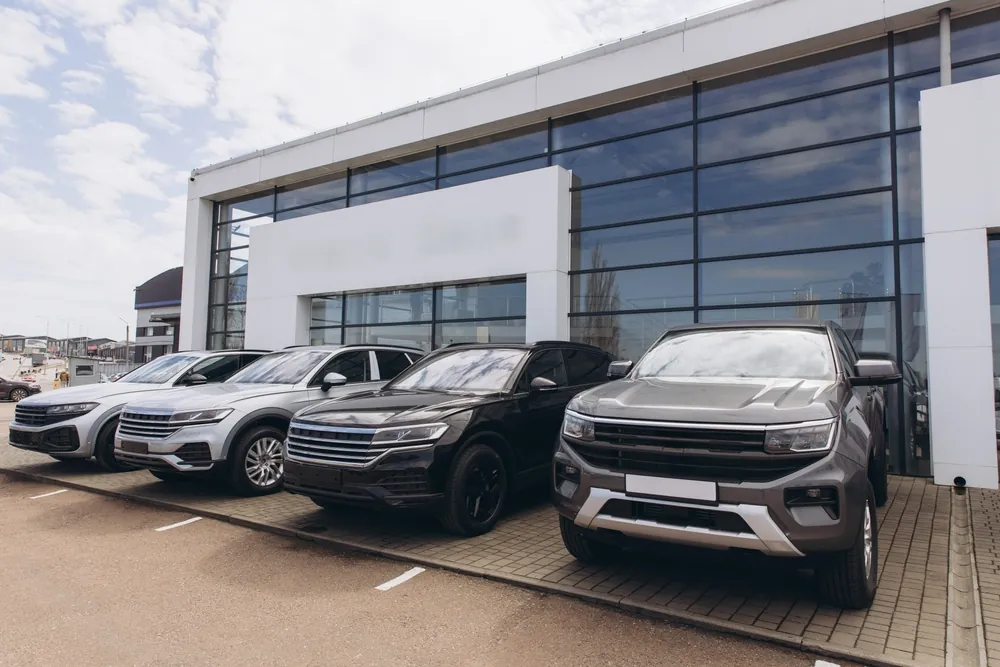 History of Auto Freight Transportation brand new cars showcased in front of car dealership exterior