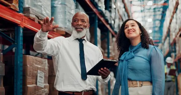 How to Protect Your Shipment in Unprecedented Times two warehouse workers cheerfully discussing inventory