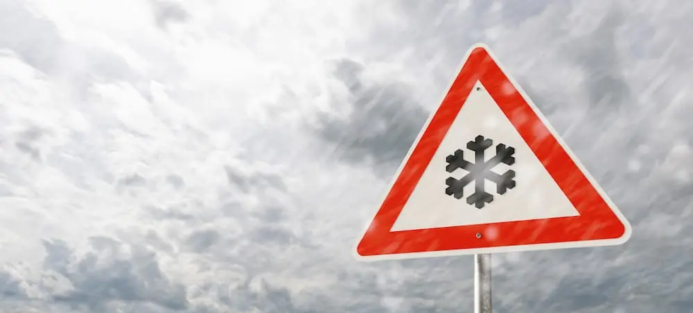 The Climate Forces Reshaping Freight in 2026 winter storm sign stands firm against blizzard