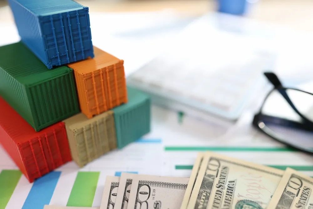tiny plastic shipping containers next to glasses and money