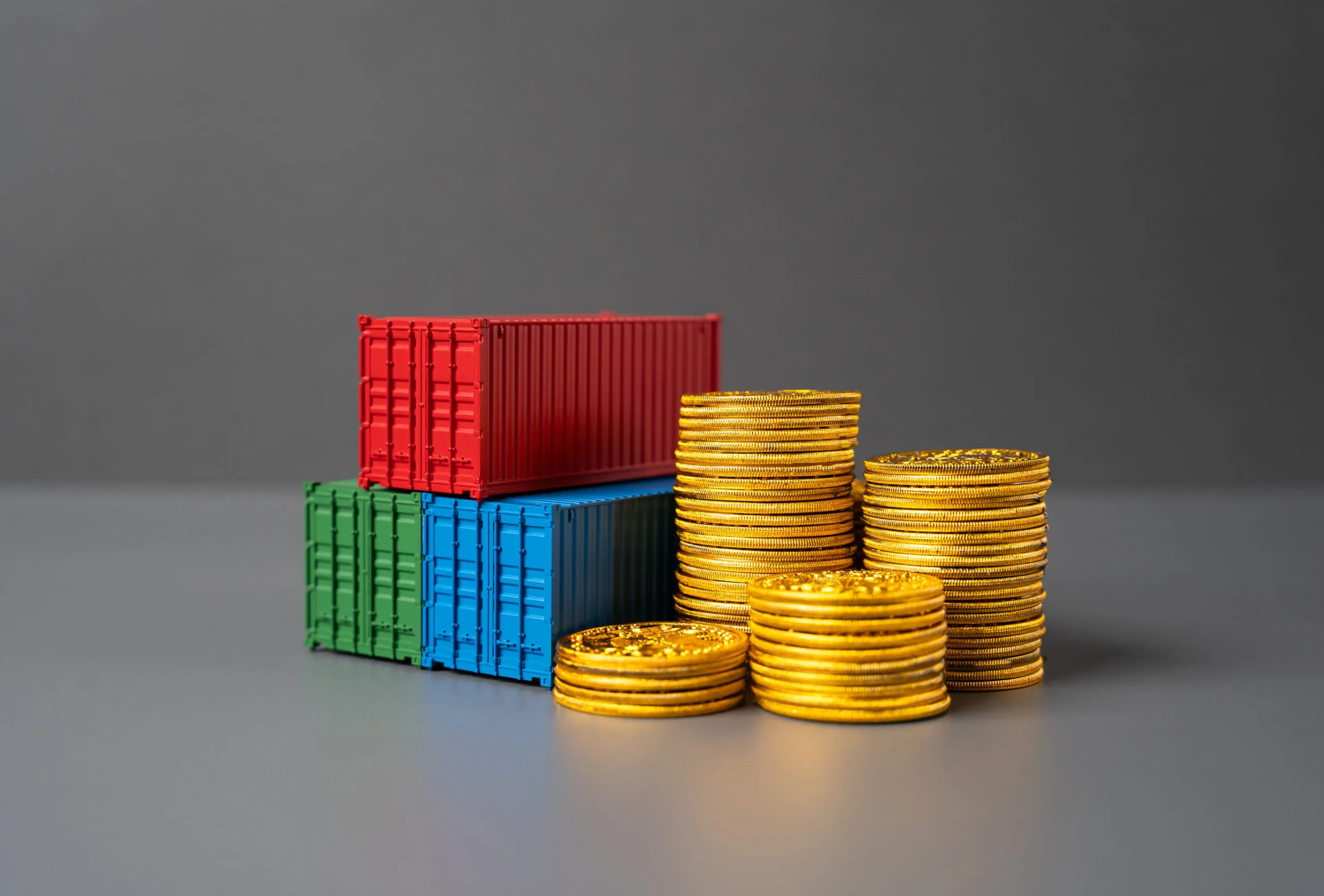 three different colored containers next to stacks of gold coins