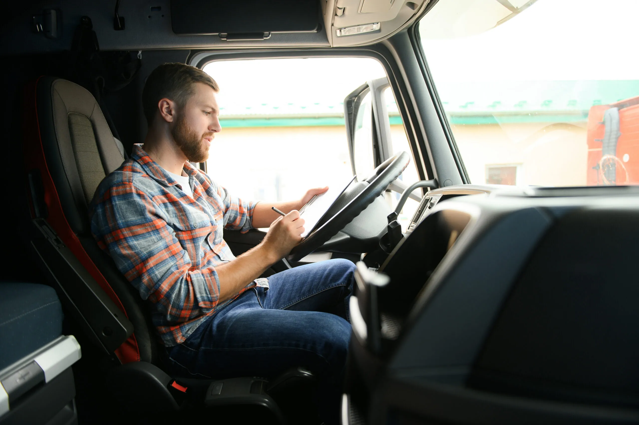 trucker driver filling out a log in his truck