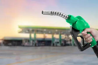 Diesel Surges RESIZ green pump held in front of gas station